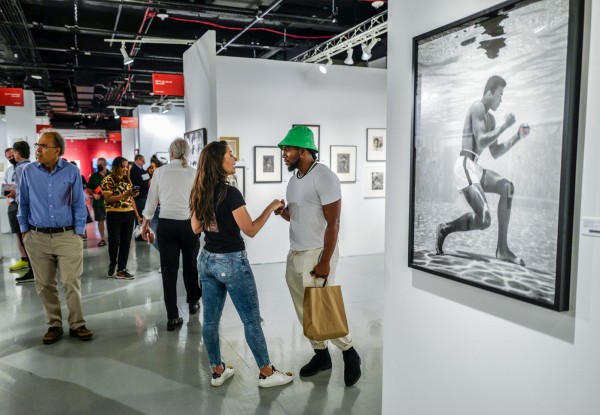 Meeting up in the busy aisles by the big photo of Mohammad Ali by Flip Schulke. (Photograph courtesy of AIPAD and Francesca Magnani, photographer)