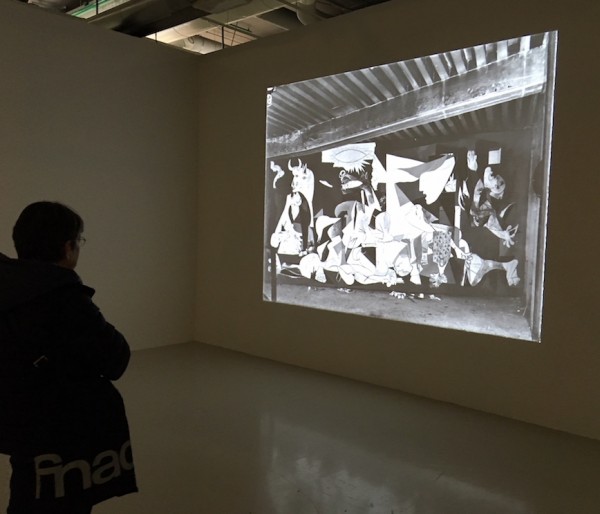 Visitor to exhibition viewing Dora Maar's photos of Picasso's Guernica.
